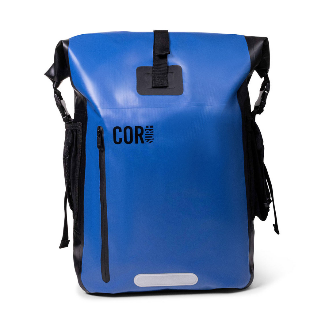 Blue COR Surf dry bag backpack with a buckled roll-top closure, front zip pocket and side mesh pockets.